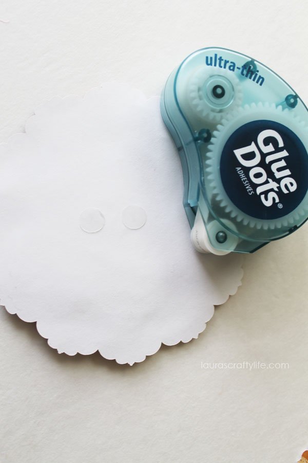 Use glue dots to attach pumpkin decoration to kraft treat bag