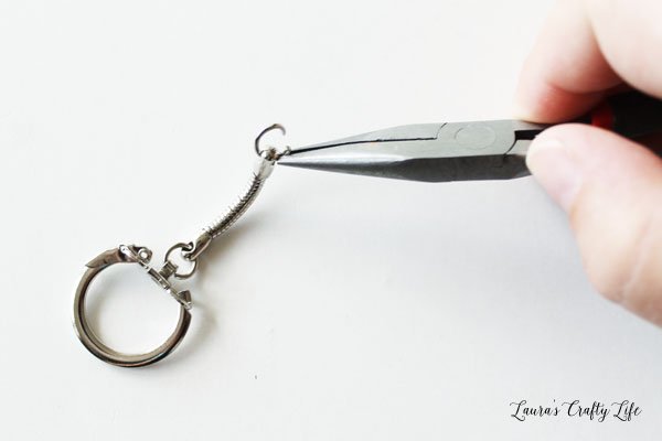 Use pliers to open jump ring on keychain