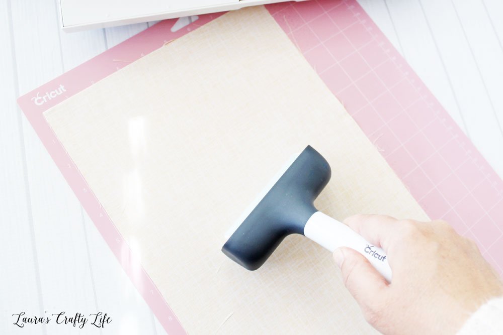 Use brayer to smooth fabric on mat